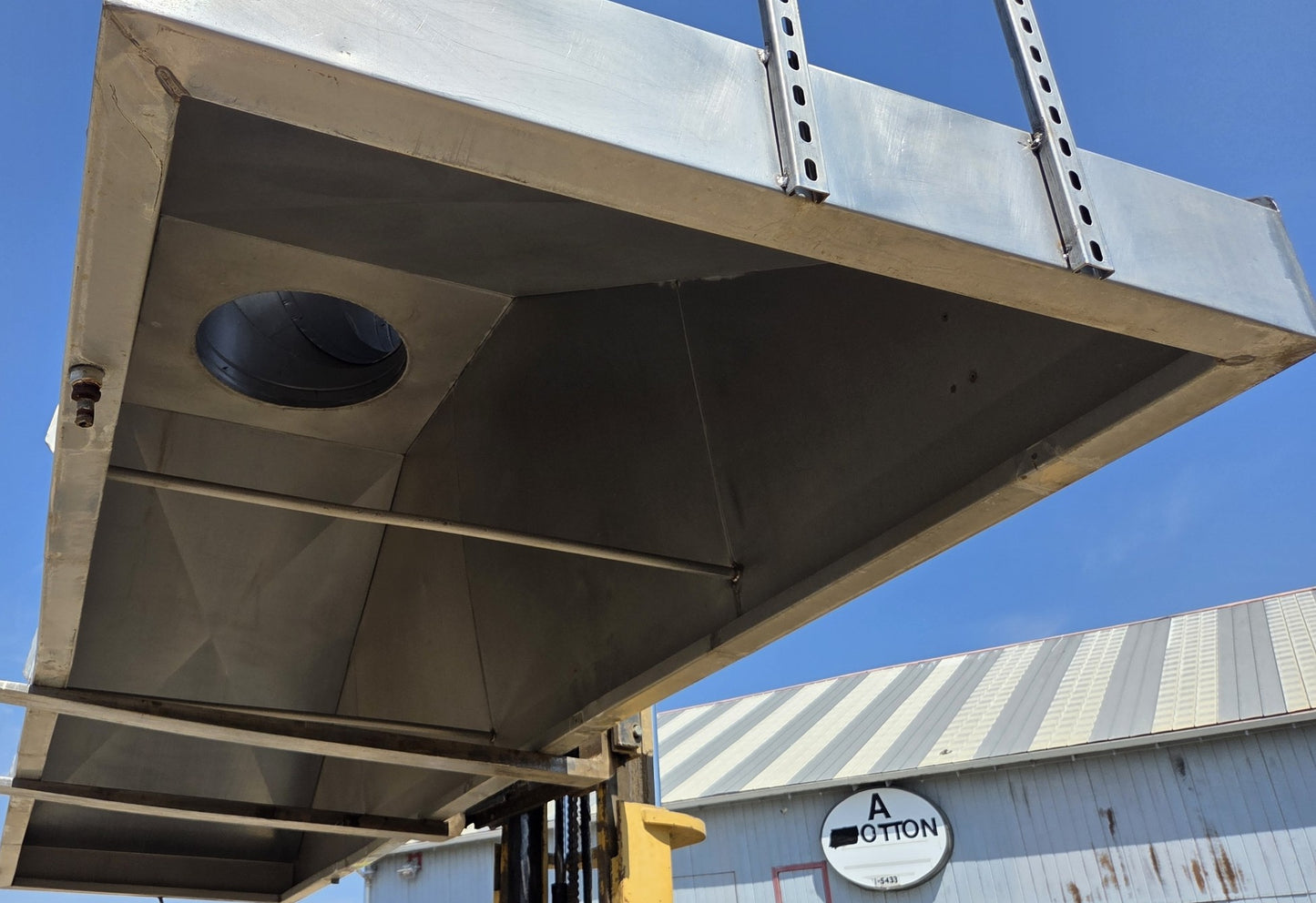 Interior of the metal canopy showing the structural paneling, smooth walls, and central exhaust port.