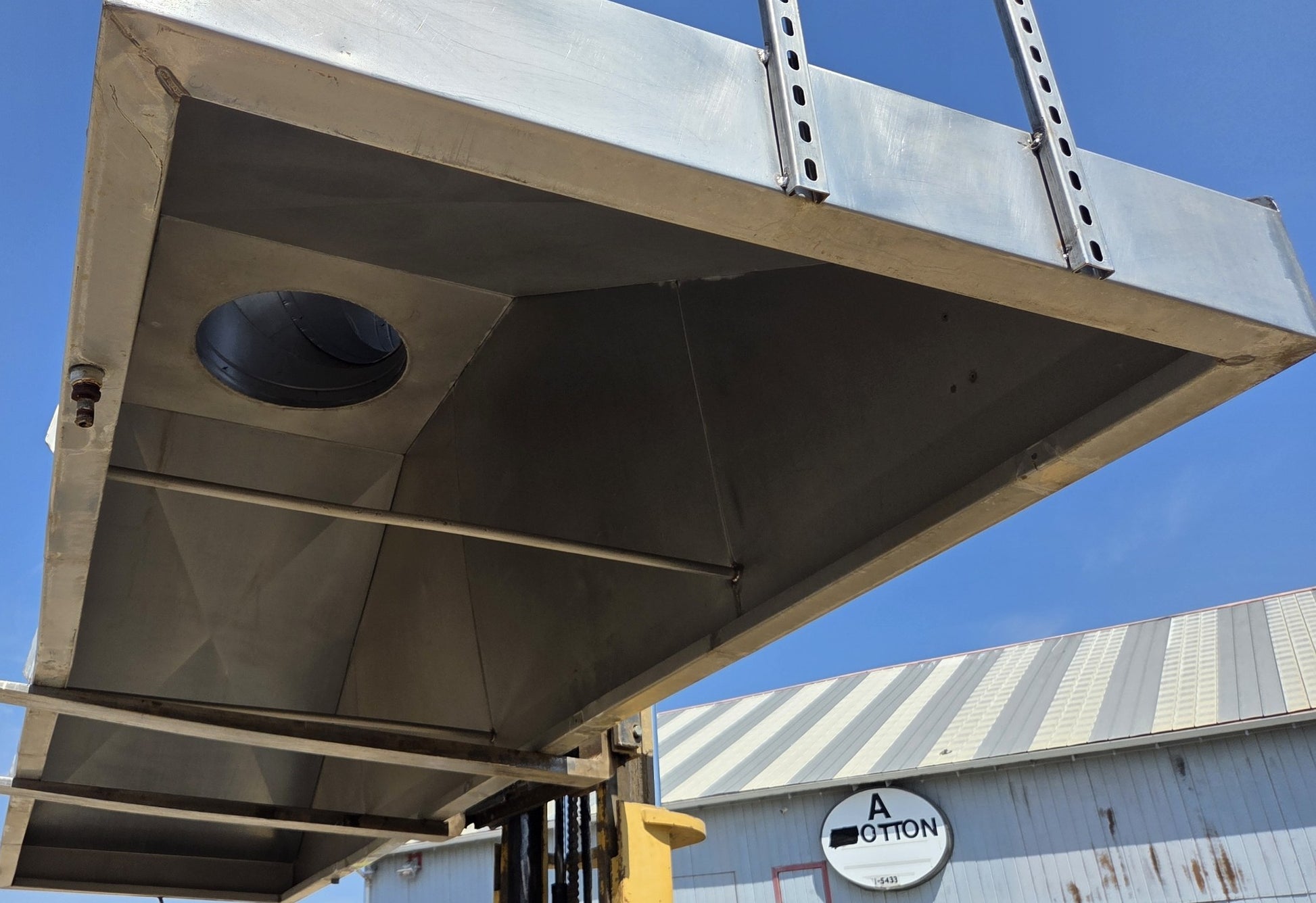 Interior of the metal canopy showing the structural paneling, smooth walls, and central exhaust port.