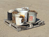 : Side angle showing a heavily cracked white plastic bucket exposing the rusted chain links inside