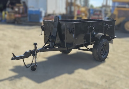  Front angle view of the black custom steel utility trailer showing the high sides, two side-mounted manual winches, and the A-frame tongue.

