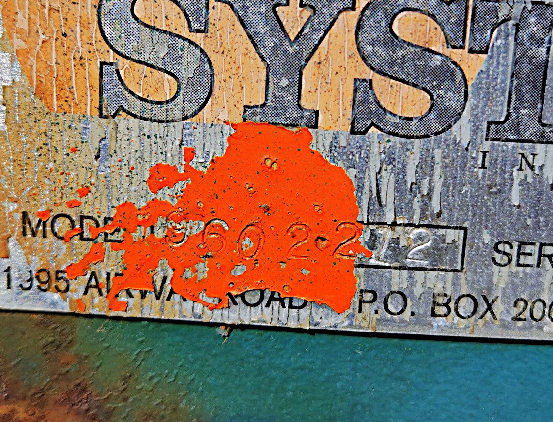 Extreme close-up of the data tag detailing Model 960-2-272 and Serial # 630-1077 partially covered by orange paint.