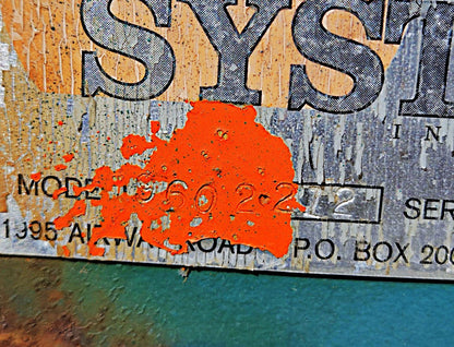 Extreme close-up of the data tag detailing Model 960-2-272 and Serial # 630-1077 partially covered by orange paint.