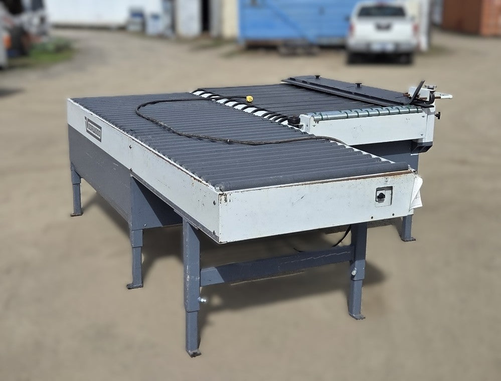 Overall wide angle of the Doucet/Voorwood return conveyor showing the grey PVC rollers and green transfer belts