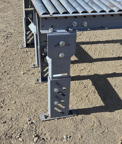 Close-up of the gray steel telescoping leg assembly showing the curved angle-adjustment slot, diagonal height-adjustment slots, and floor-mount foot plate.