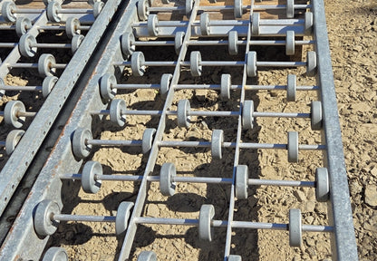  Close-up overhead view of the galvanized steel skatewheels arranged in an alternating 4-wheel and 5-wheel staggered pattern across two longitudinal center support ribs.
