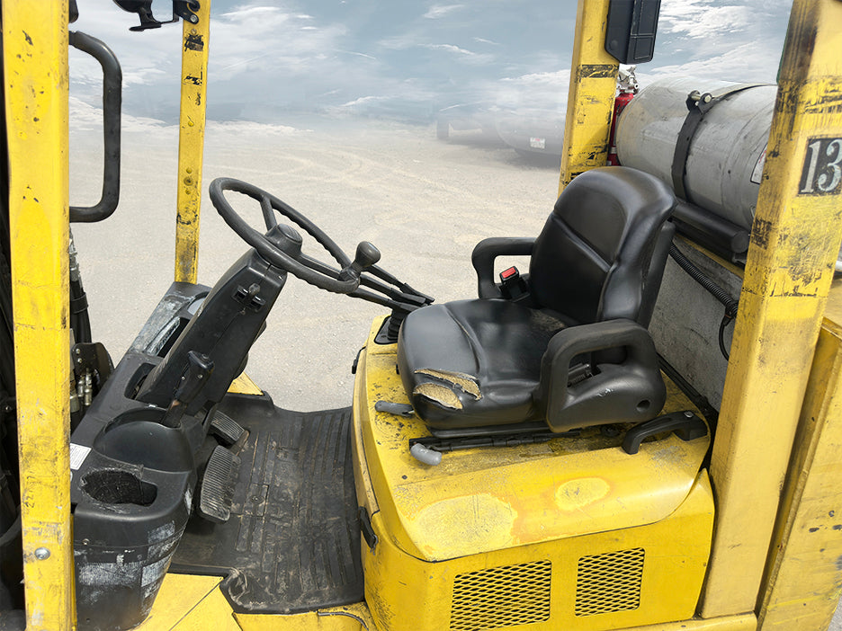 Hyster S80XM-BCS 8000 lb LP gas cushion tire forklift operator cabin torn seat steering wheel hydraulic controls.