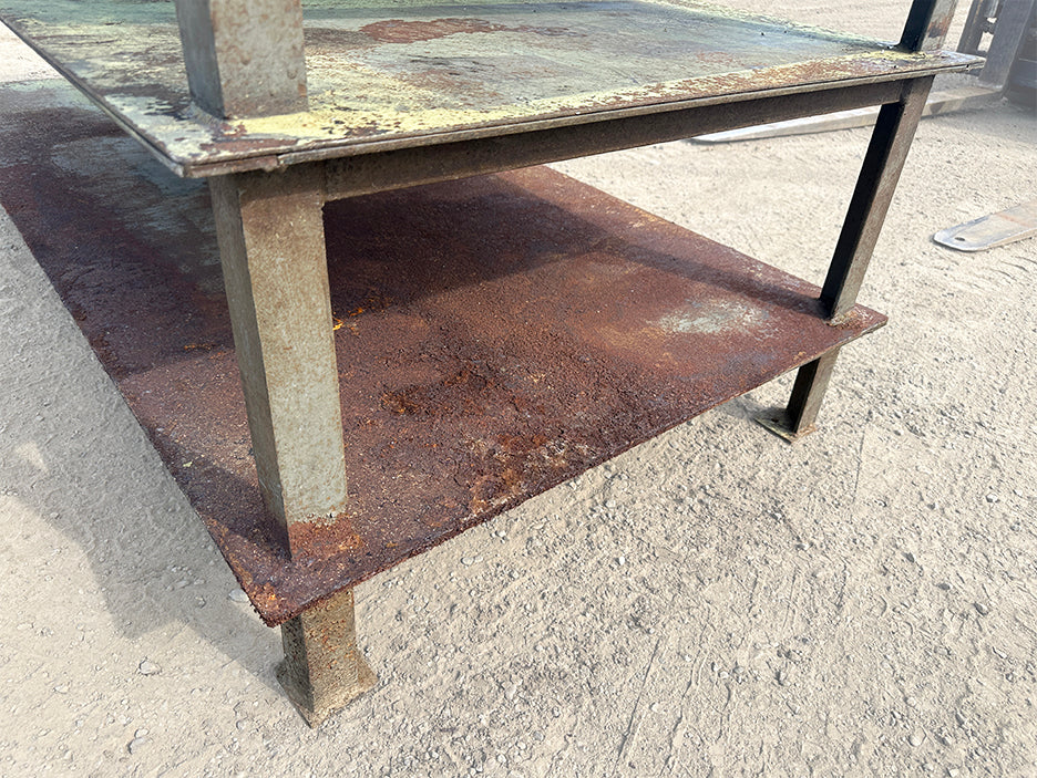Heavy-duty steel industrial welding workbench bottom shelf structural steel legs surface rust 