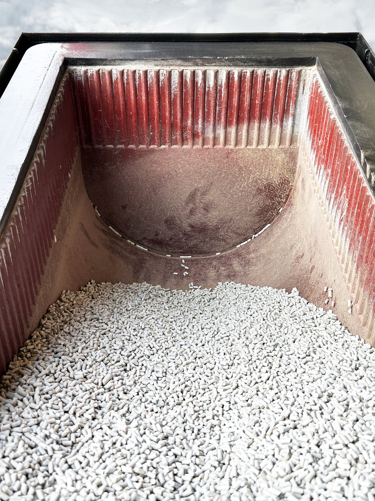 Abrasive Finishing Inc SuperQuiet Burr Bench vibratory tumbler internal tub view showing red ribbed urethane lining and grey ceramic stone tumbling media