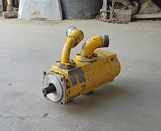 Opposite side profile of the triple-stage hydraulic pump detailing the heavy cast iron construction and section tie-bolts.
